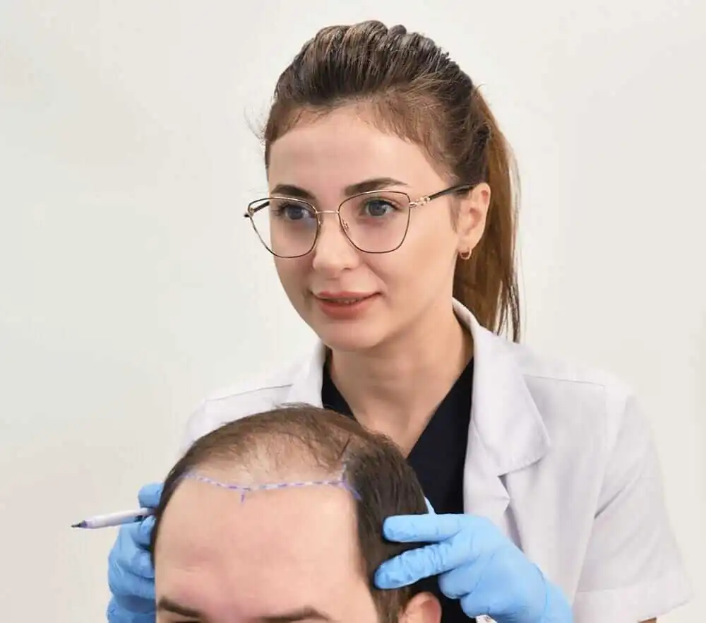 Arts van Hairtec tekent de nieuwe haarlijn af bij een patiënt